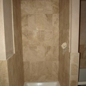 Honed filled travertine shower walls.