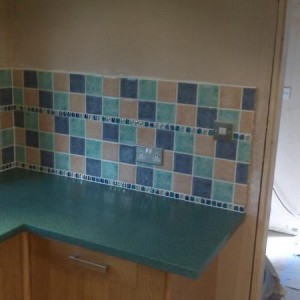 16k Oak Kitchen Installation with Silica(resin) worktops. Tiling with 100x100 ceramics with glass borders