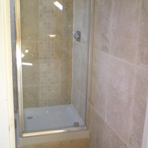 travatine bathroom with 2 vertical mosaic borders