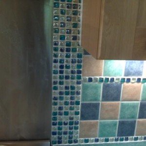 100x100 ceramics with glass borders. Small cut @ side of cupbard, customer gets what the customer wants, she wanted border tight to splashback