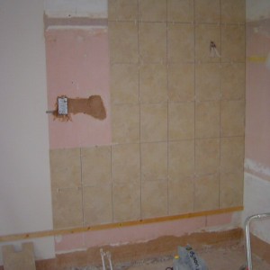 one wall nearly tiled, shower water and electrics in, shaver socket electrics in