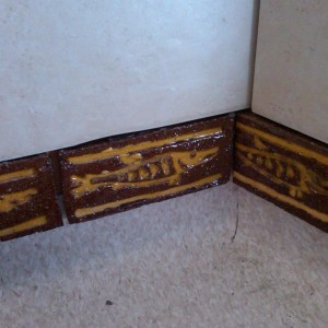 Hand made 'fish' tiles used as a skirting detail aboved the coved vinyl.