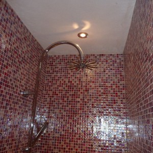 Double shower enclosure tiled in pink glass mosaics