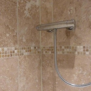 Mosaic set flush with the travertine tile surface