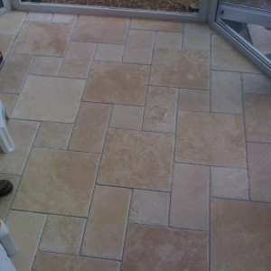 Chiselled edge travertine in the classic step pattern in this conservatory