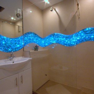 These pictures are of my bathroom. The walls are clad with Kerlite porcelain panels which are upto 3 metres by 1 metre and 4mm thick! The glass panels I had mad in single pieces by a glass artist and then they are backlit with colour changing fibre optics. Its awsome!