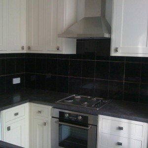 B&Q Black marble effect tiles over the black worktops