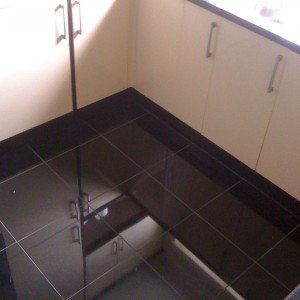 Polished black granite floor supporting a Wickes kitchen