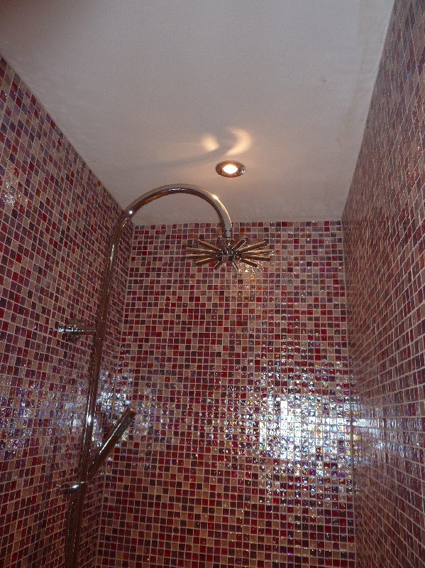 Double shower enclosure tiled in pink glass mosaics