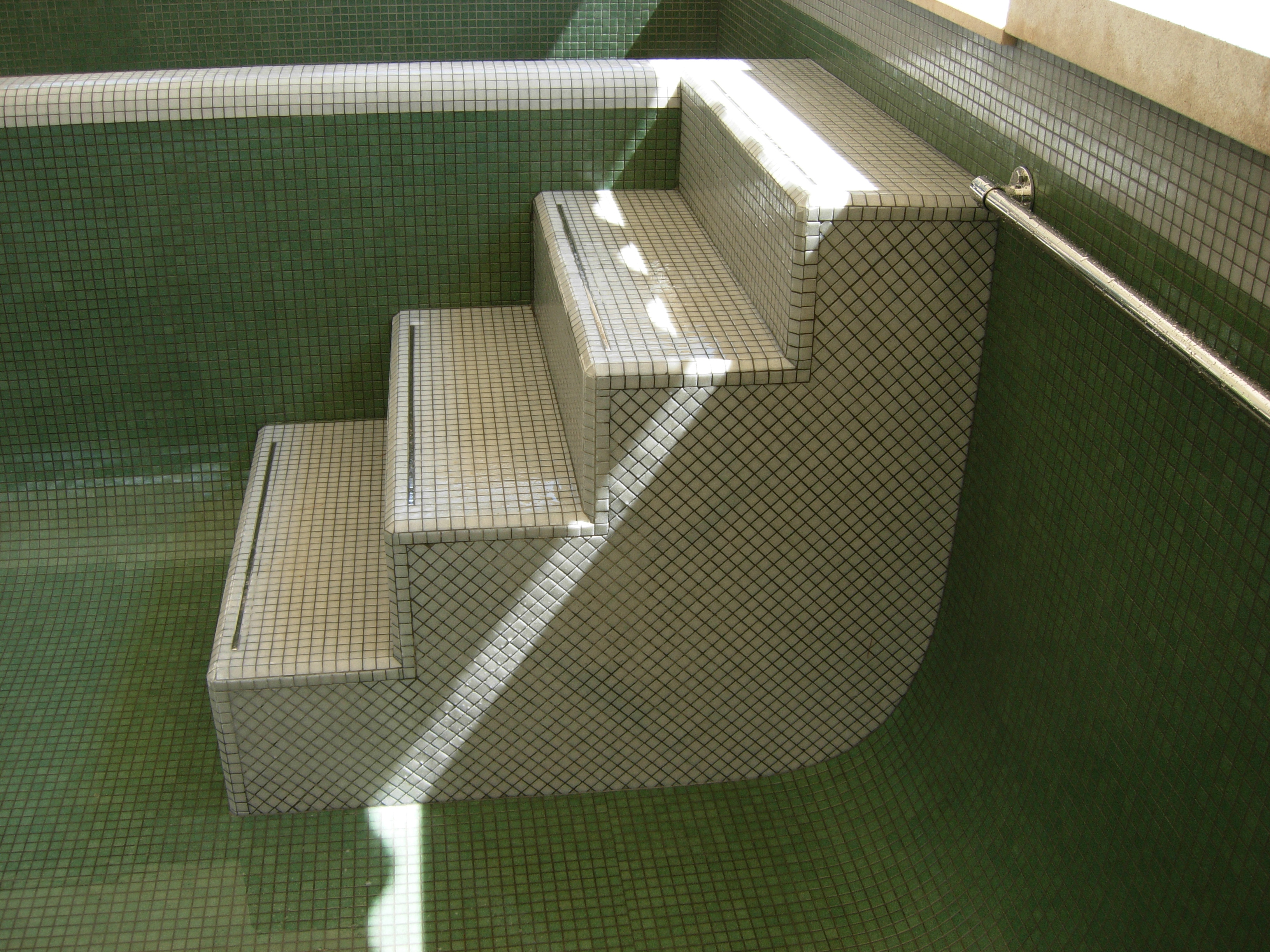 light grey pool steps with stainless steel inlay