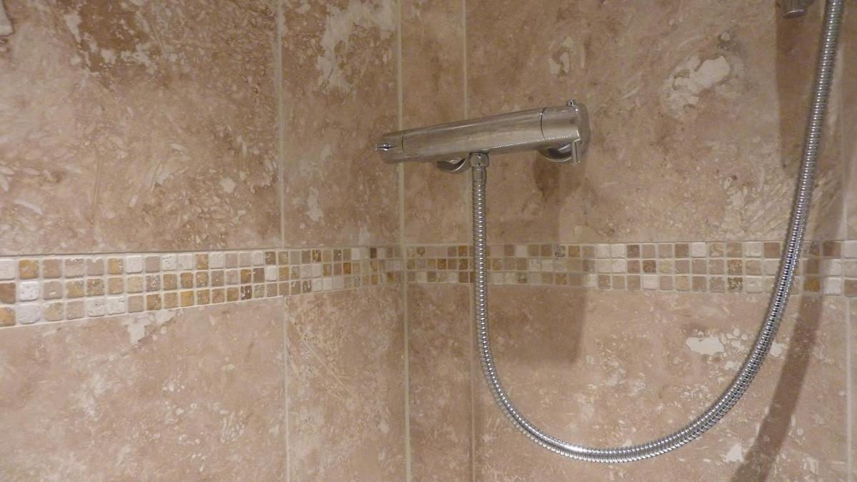 Mosaic set flush with the travertine tile surface