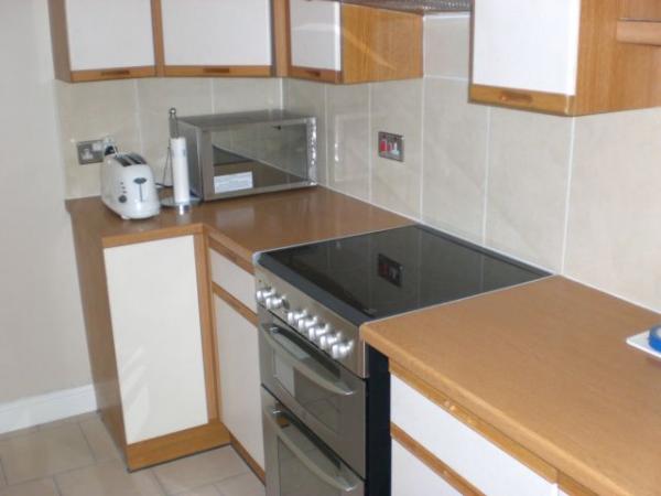 Oven kitchen - sorry about reflection - mirrored microwave door + glossy tiles + sun! Do the big tiles look weird on a splashback??! Pain in the *** cutting out the socket holes with an angle grinder.