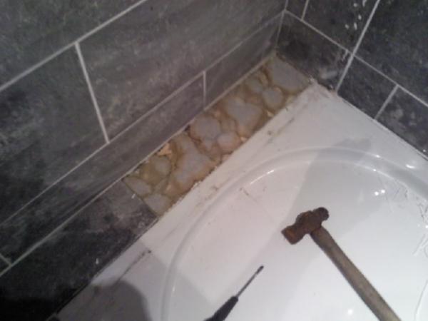 the gap between the wall and shower tray has been filled with expanding foam, then tiled