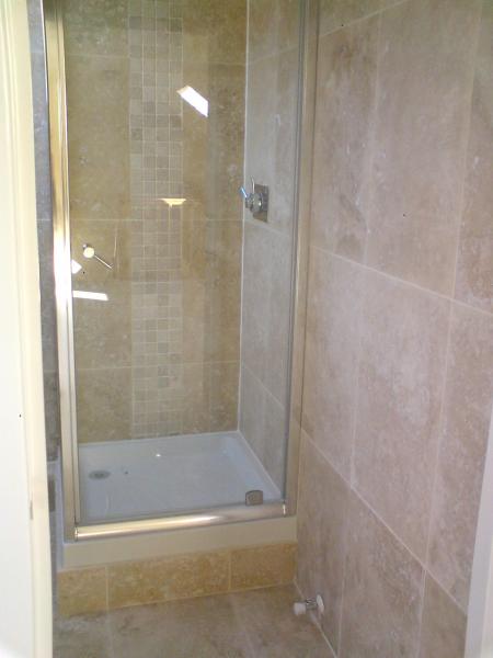 travatine bathroom with 2 vertical mosaic borders